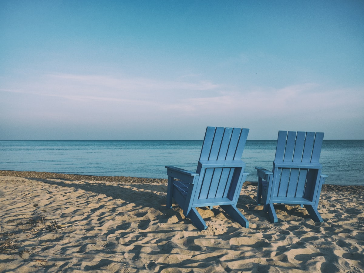 Zwei blaue Strandstühle am Meer